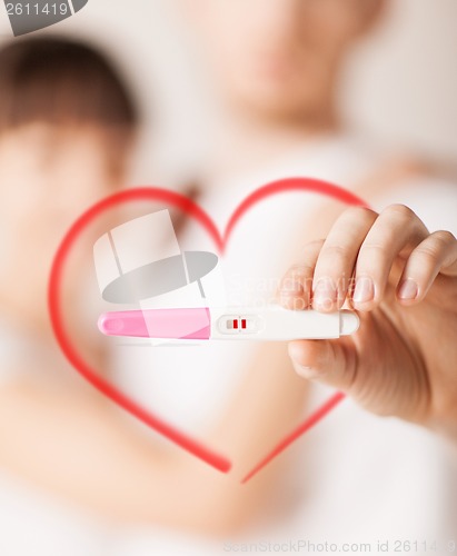 Image of woman and man hands with pregnancy test