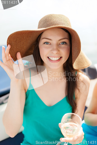 Image of smiling girl in hat with champagne glass