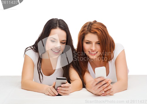 Image of two smiling teenagers with smartphones