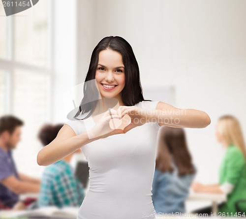 Image of smiling girl showing heart with hands