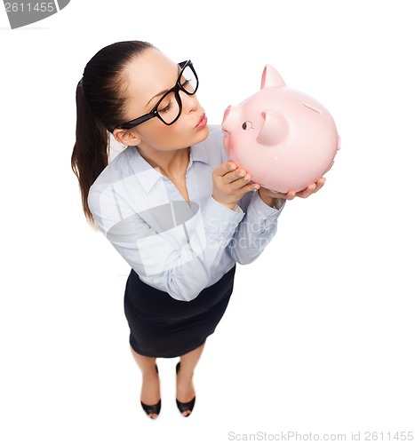 Image of happy businesswoman in eyeglasses with piggy bank