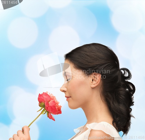 Image of smiling woman smelling flower