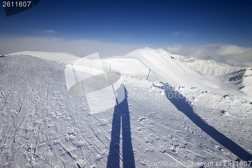 Image of Shadows of skier and snowboarder on snow