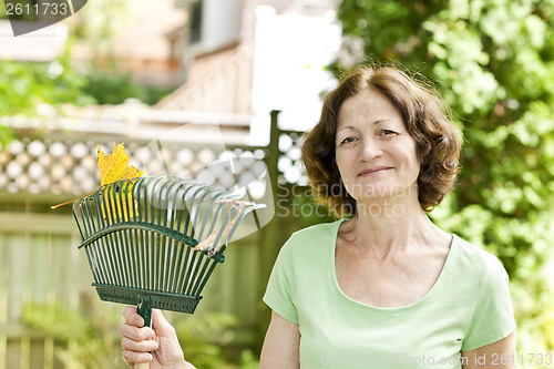 Image of Senior woman holding rake