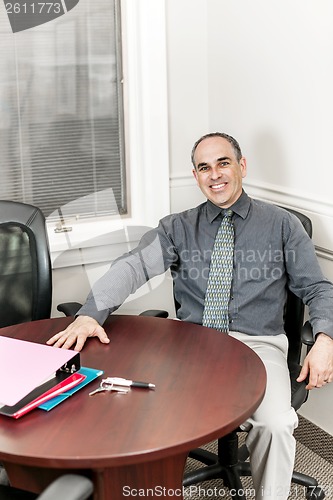 Image of Businessman sitting in office meeting room