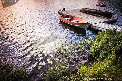 Image of Rowboat at lake shore at sunrise