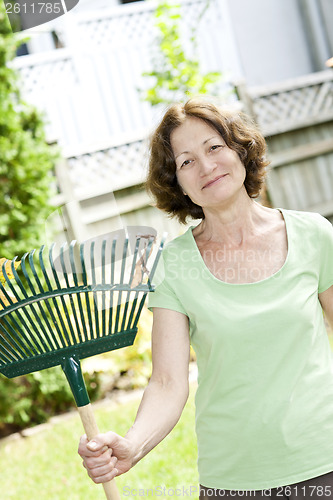 Image of Senior woman holding rake