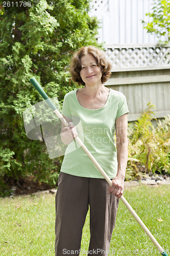 Image of Senior woman holding rake