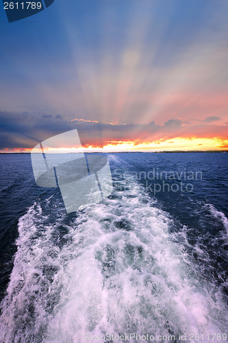 Image of Sunset over ocean with boat wake