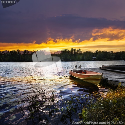 Image of Boat docked on lake at sunset