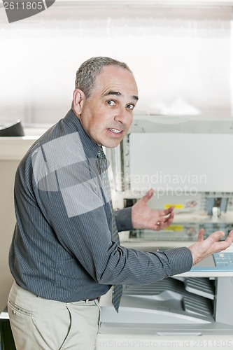 Image of Man frustrated with photocopier