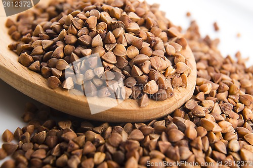 Image of Buckwheat seeds on wooden spoon in closeup 