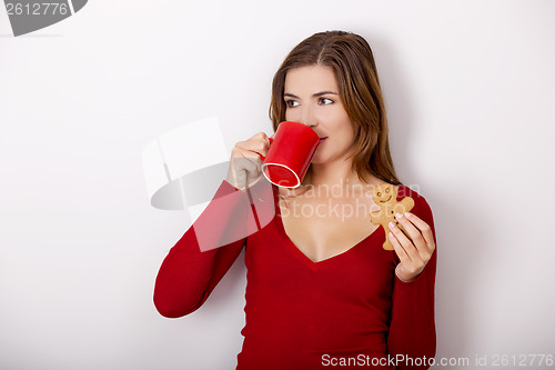 Image of Woman drinking coffee with cookies