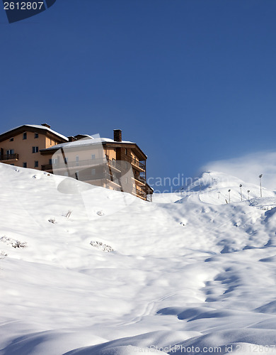 Image of Off-piste slope and hotel at sun day