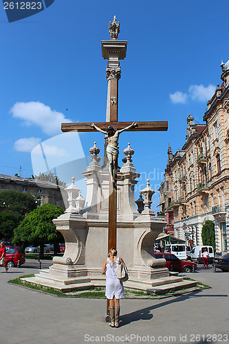 Image of girl praying near the croos in religious place