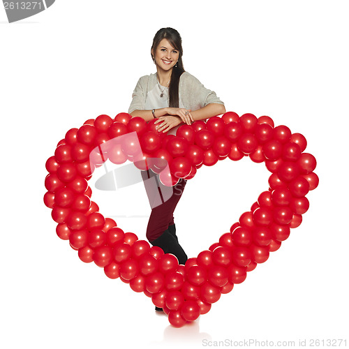 Image of Smiling woman holding red balloon heart