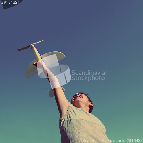 Image of boy running airplane model - vintage retro style