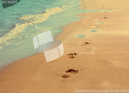 Image of footprints on sand beach - vintage retro style