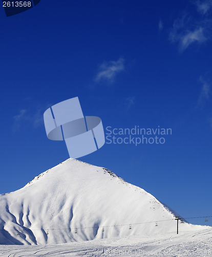 Image of Ski slope with ropeway at sun winter day