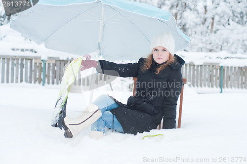 Image of Girl with fins sitting in snow