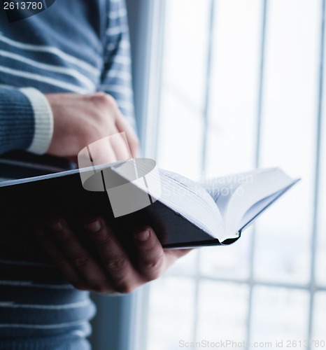 Image of Man reading. Book in his hands.