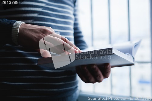 Image of Man reading. Book in his hands.