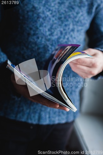Image of A man looks at a magazine. Press hands.
