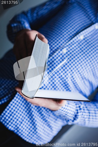 Image of Man reading. Book in his hands.