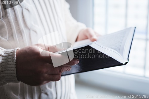 Image of Man reading. Book in his hands.