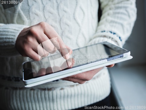 Image of The man uses a tablet PC. Modern gadget in hand.