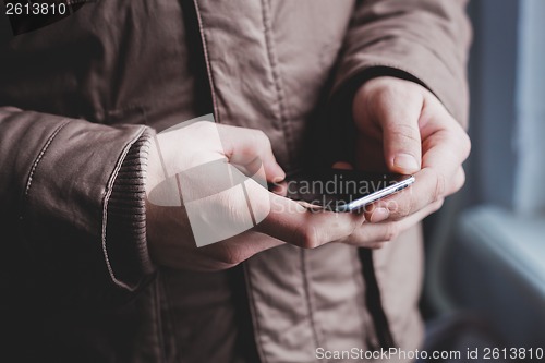Image of The man is using a smartphone. Modern mobile phone in hand.