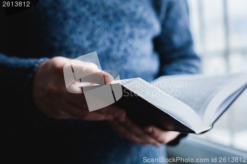 Image of Man reading. Book in his hands.