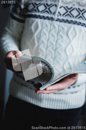 Image of A man looks at a magazine. Press hands.