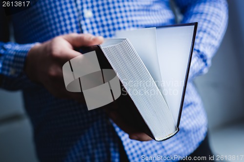 Image of Man reading. Book in his hands.