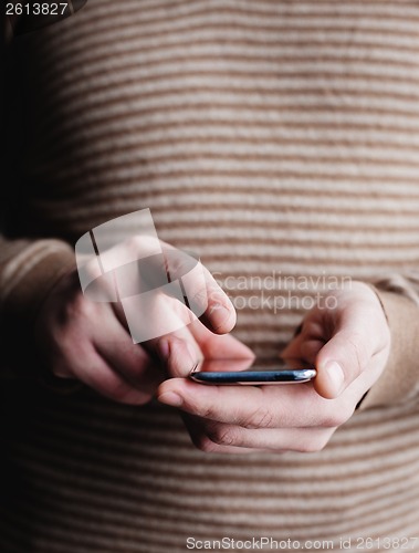 Image of The man is using a smartphone. Modern mobile phone in hand.