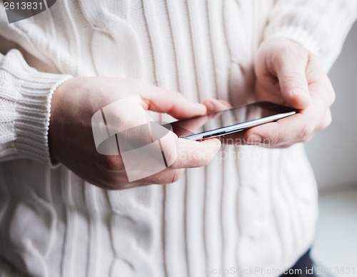 Image of The man is using a smartphone. Modern mobile phone in hand.