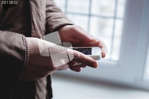 Image of The man is using a smartphone. Modern mobile phone in hand.