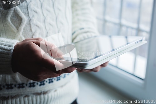 Image of The man is using a smartphone. Modern mobile phone in hand.