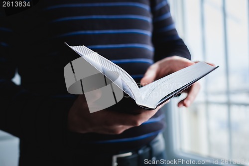 Image of Man reading. Book in his hands.