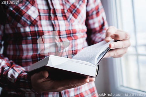 Image of Man reading. Book in his hands.