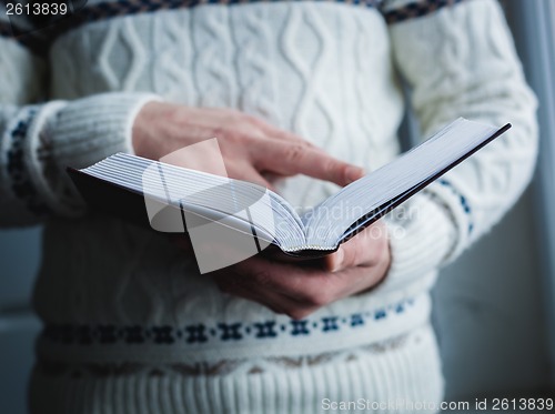 Image of Man reading. Book in his hands.