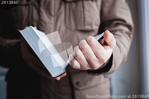 Image of Man reading. Book in his hands.