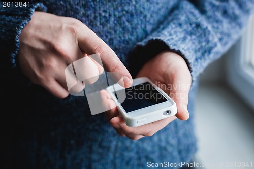 Image of The man is using a smartphone. Modern mobile phone in hand.