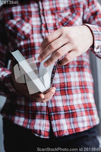 Image of Man reading. Book in his hands.