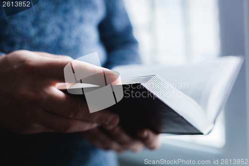 Image of Man reading. Book in his hands.