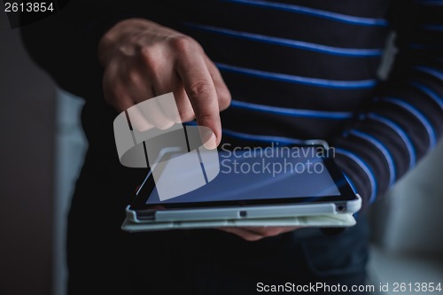 Image of The man uses a tablet PC. Modern gadget in hand.