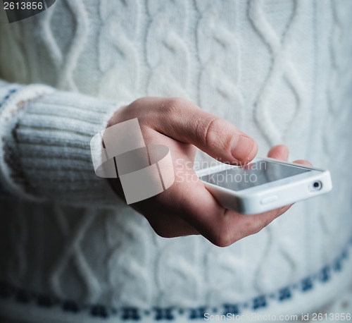 Image of The man is using a smartphone. Modern mobile phone in hand.