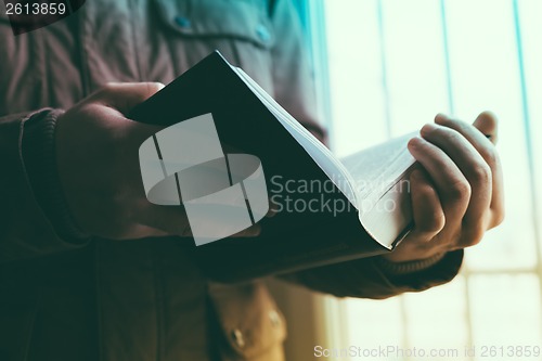 Image of Man reading. Book in his hands.