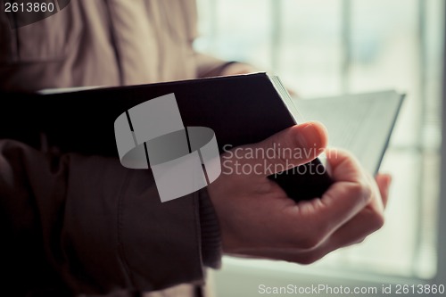 Image of Man reading. Book in his hands.