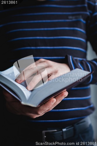 Image of Man reading. Book in his hands.